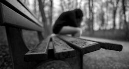 Lonely figure sitting on a bench.
