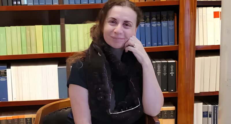 Person seated in a library setting.