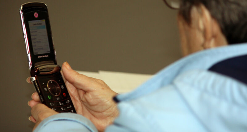 A teen with a flip-phone.